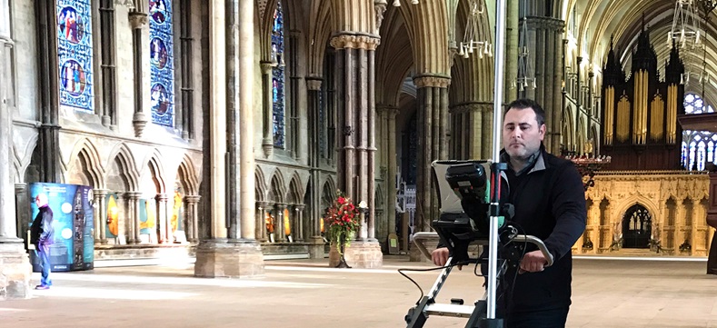 Mann mit Vermessungsgerät in einer Kirche